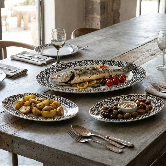 Dining table set with plates of food and wine glasses in a rustic setting.
