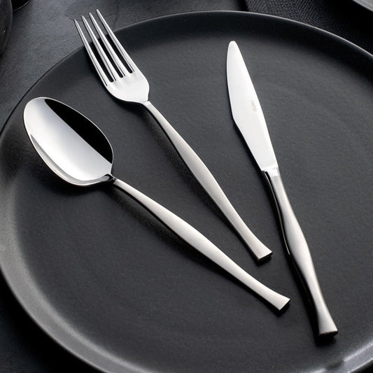 A set of silver cutlery including a soup ladle, service spoon, service fork, and a knife and fork set displayed on a dark plate.