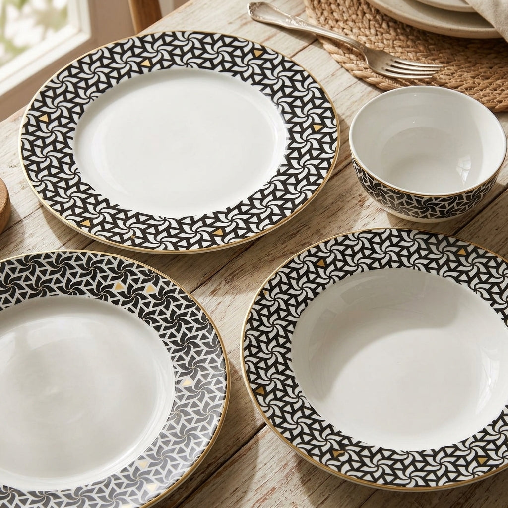 Set of ceramic plates with black geometric patterns on a wooden table.