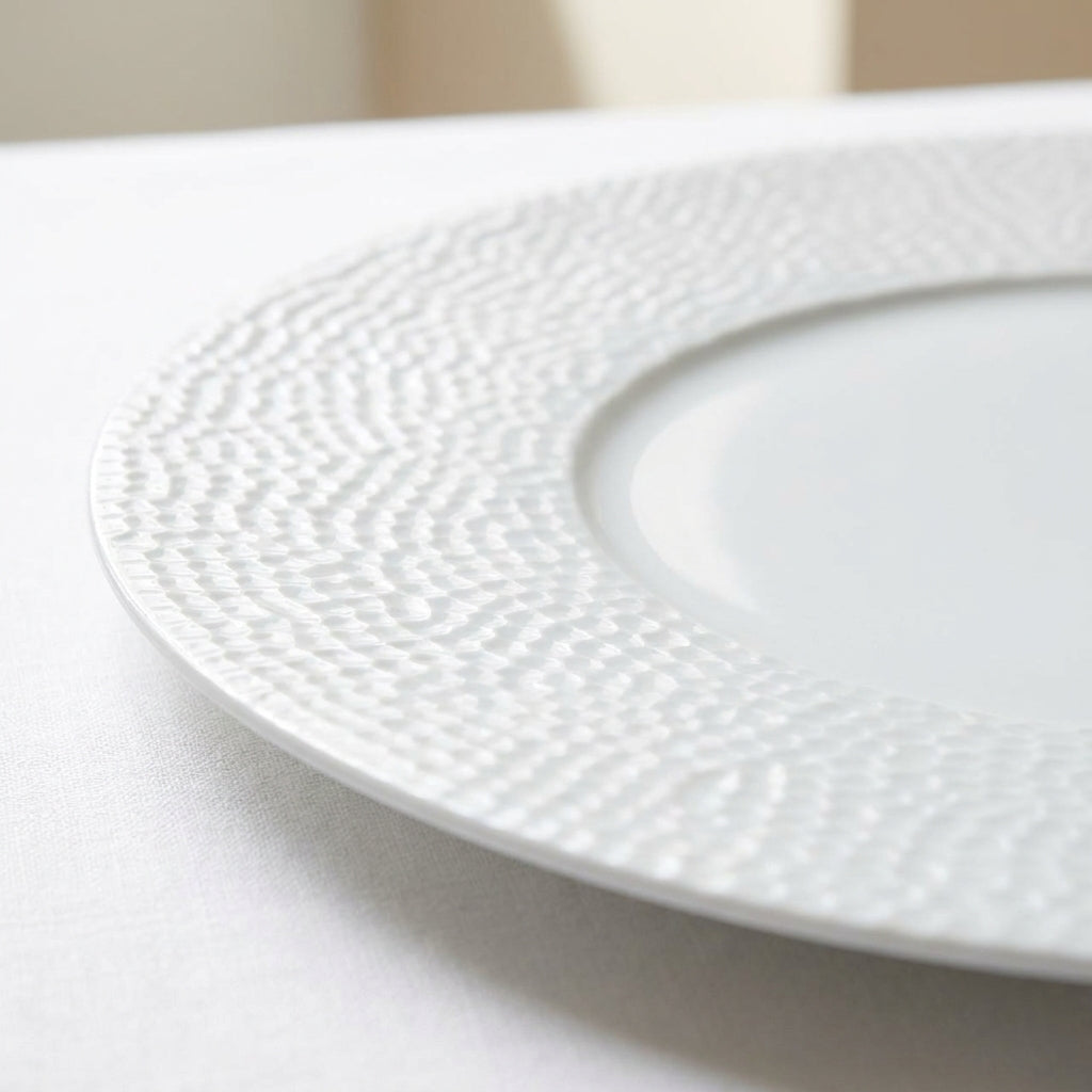 White ceramic plate with textured rim on a light background