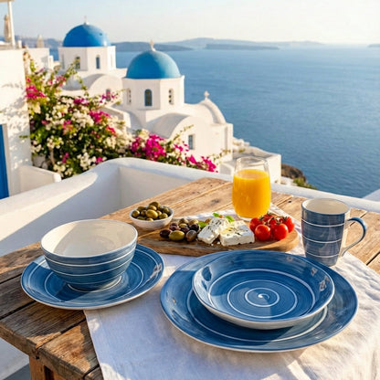 Outdoor dining setup with Greek-style plates and a view of Santorini's iconic blue-domed churches.