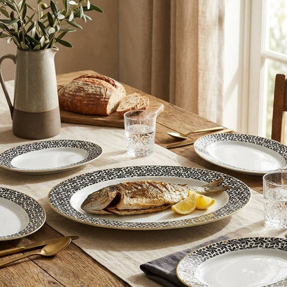 Dining table set with plates, bread, and glasses on a wooden table.