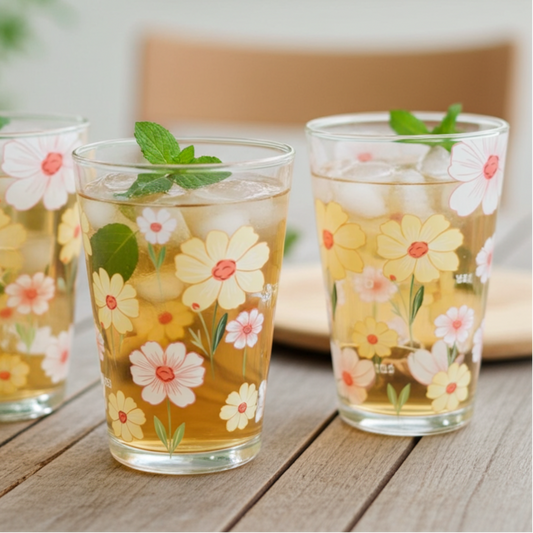 Three glasses of floral-patterned iced tea on a wooden surface with a blurred background