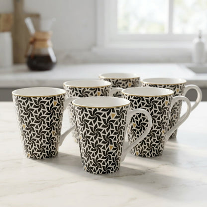 Set of patterned mugs on a light surface with a blurred kitchen background