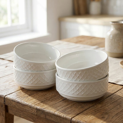 Set of white ceramic bowls with textured pattern on a wooden table