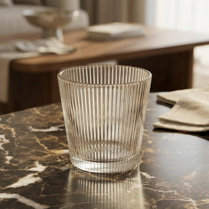 Clear glass on a marble table with a blurred living room background