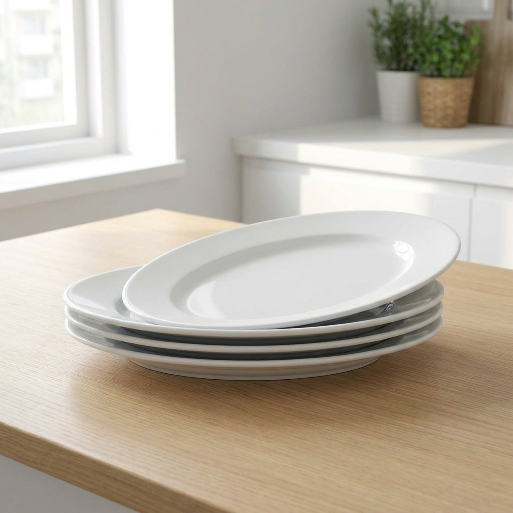 Stack of white oval plates on a wooden table with a kitchen background