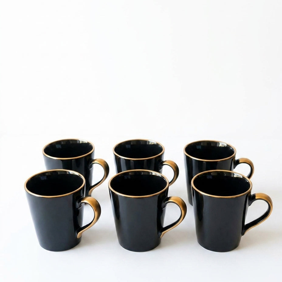 Set of six black mugs with gold handles on a white background