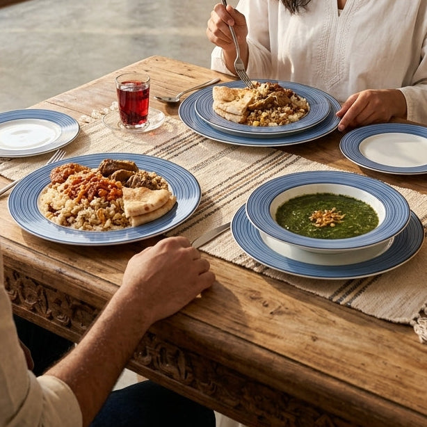 Man and woman sitting at a wooden table in a kitchen, enjoying a meal together.