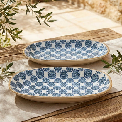 Two ceramic plates with blue geometric pattern on a wooden surface with greenery.