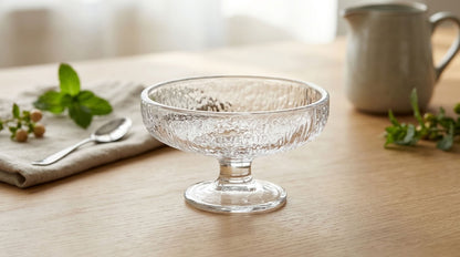 Clear textured glass dessert coupe on a light wooden table