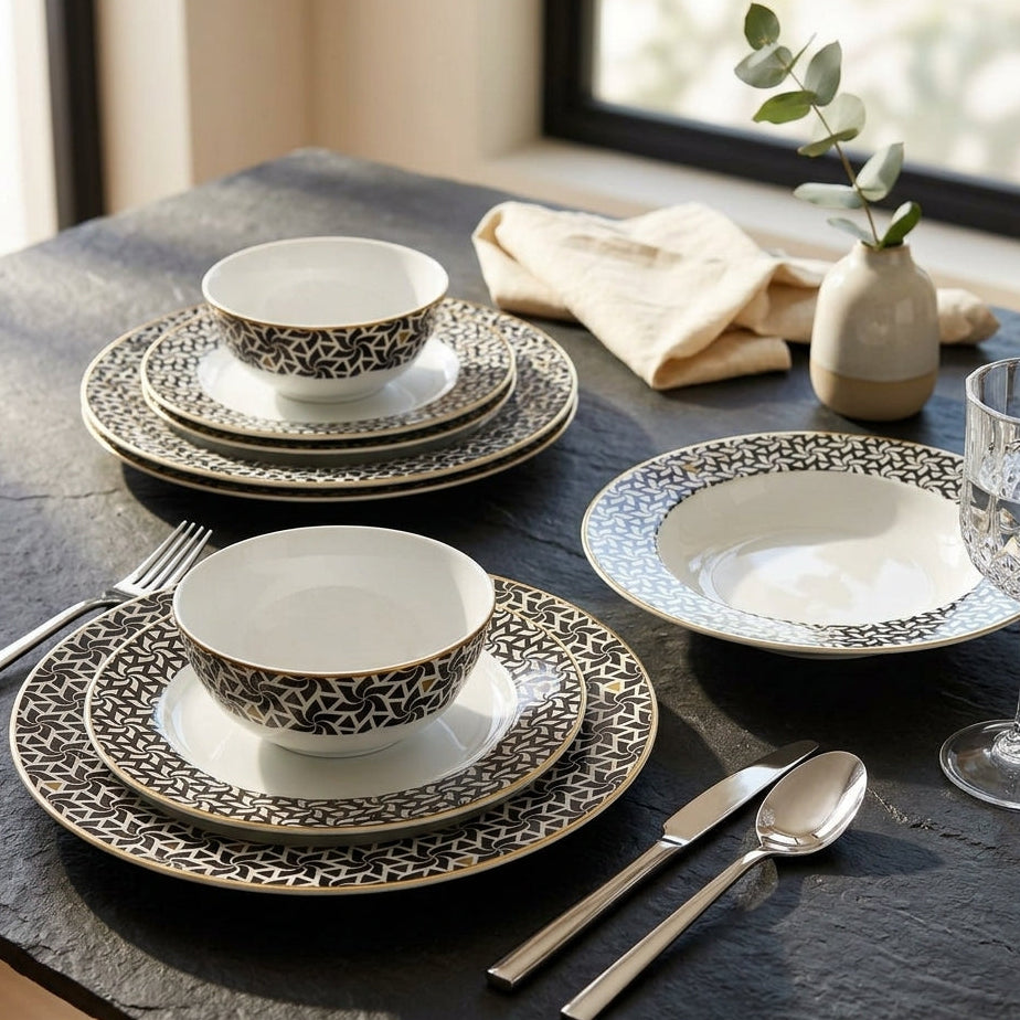 Dining table setting with patterned ceramic plates, bowls, and cutlery on a dark surface.