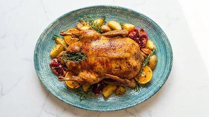 Roasted duck with vegetables on a blue plate