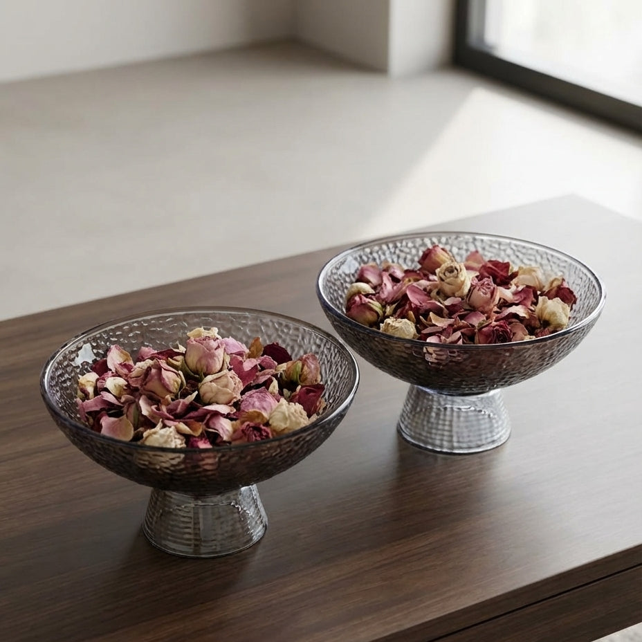 Two decorative bowls with dried flowers on a wooden surface.