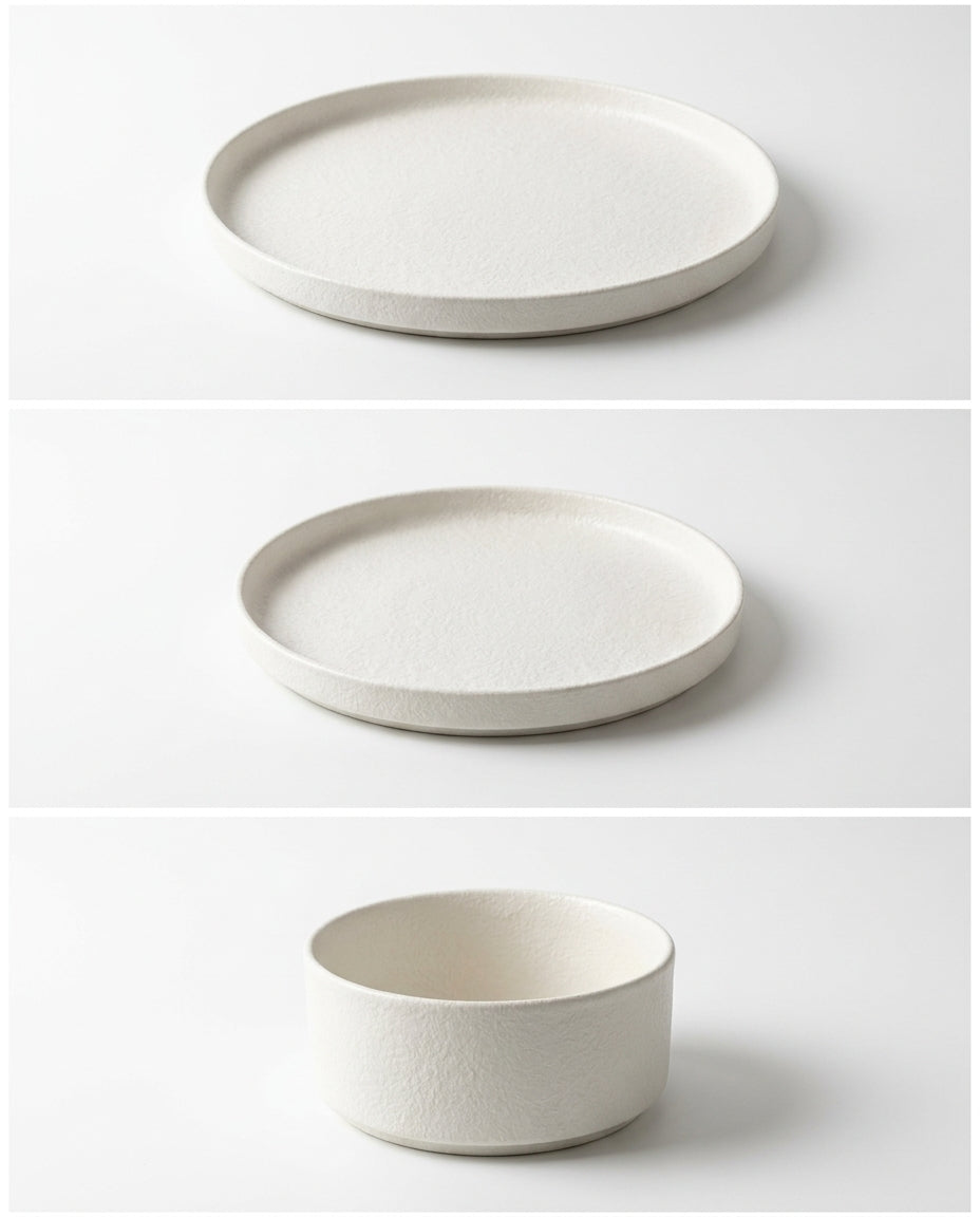 Set of white ceramic plates and a bowl on a light gray background