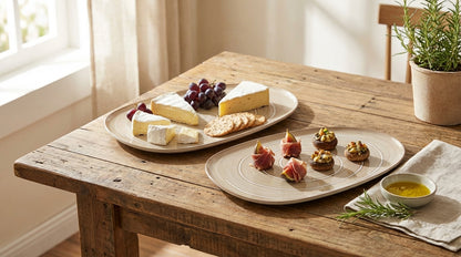Wooden table with a cheese platter and appetizers in a bright room.
