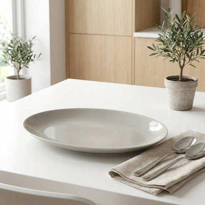 Beige ceramic plate on a white surface with a beige napkin and silverware, set against a neutral background.
