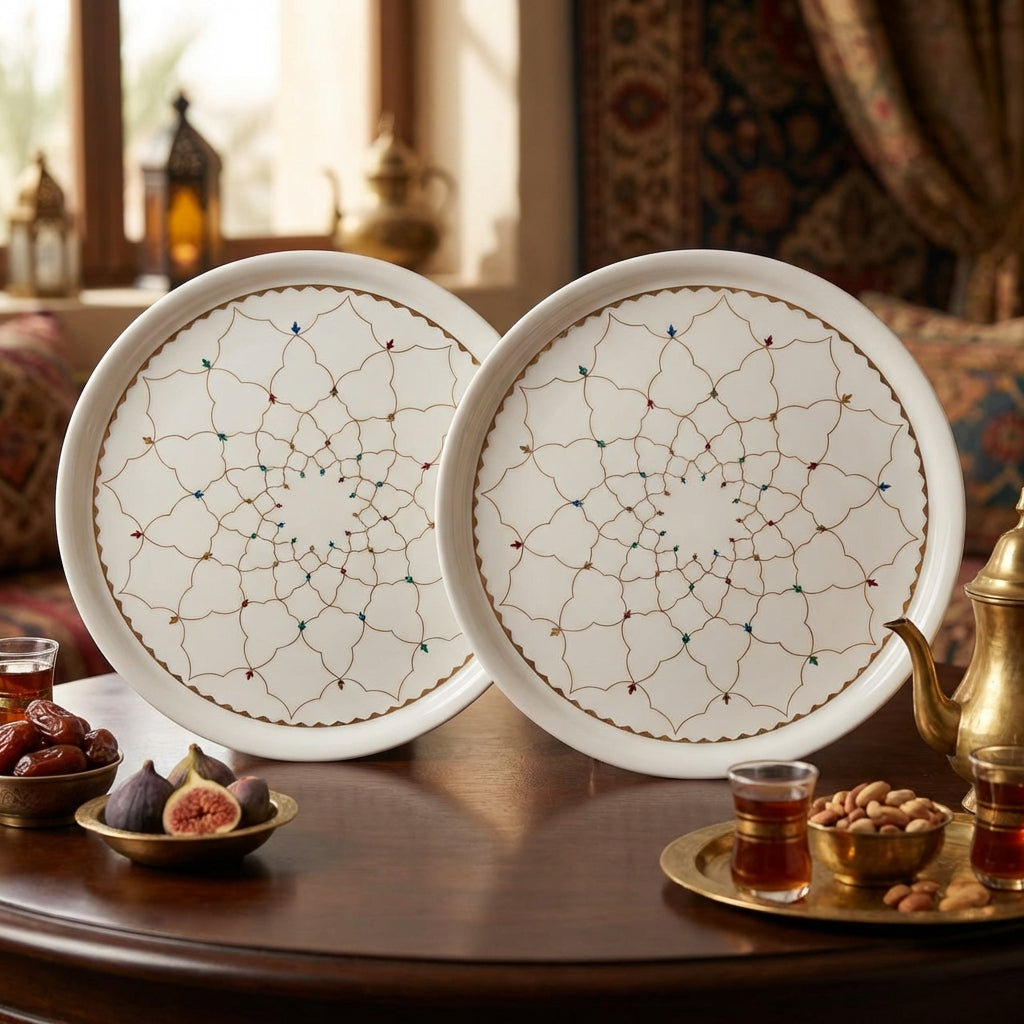 Two ceramic plates with decorative patterns on a table with tea and snacks.