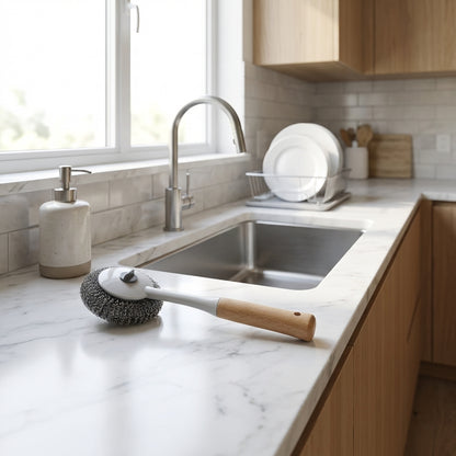 Cleaning brush on a kitchen counter with a sink and window in the background