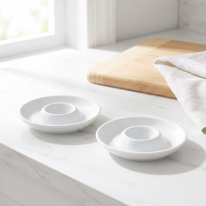 Two white ceramic bowls on a light wooden surface with a neutral background