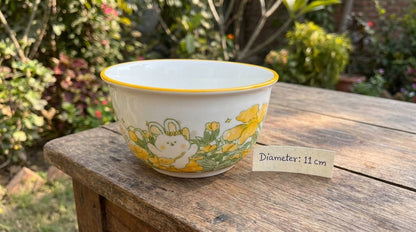 Ceramic bowl with floral design on a wooden surface outdoors