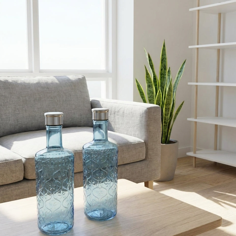 Two blue textured bottles on a wooden coffee table in a bright living room.