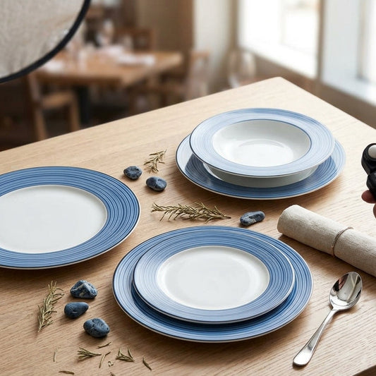 Blue and white ceramic plates on a wooden table with a person using a smartphone.