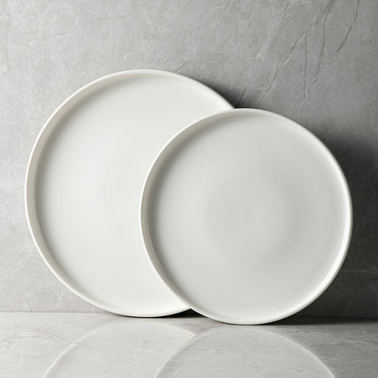 A set of white porcelain plates of two different sizes placed on a marble surface.